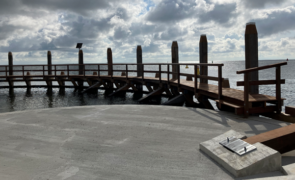 Houten geleidewerk Haven Oudeschild met een blauwe lucht met wolken